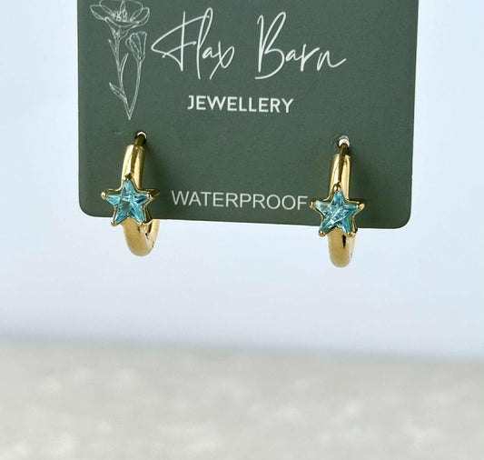 Gold hoop earrings with turquoise star stones on a Flax Barn Jewellery card.